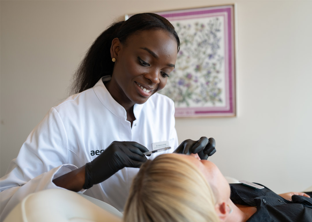 Frau Dr. Amara Loweg bei Botox-Behandlung einer liegenden Patientin