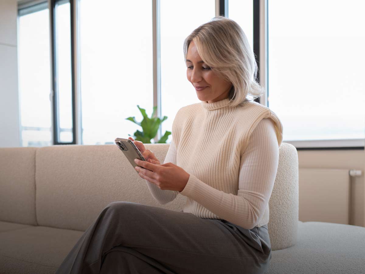 Patientin blickt auf ihr Handy im Wartebereich im aegz. in Darmstadt. 