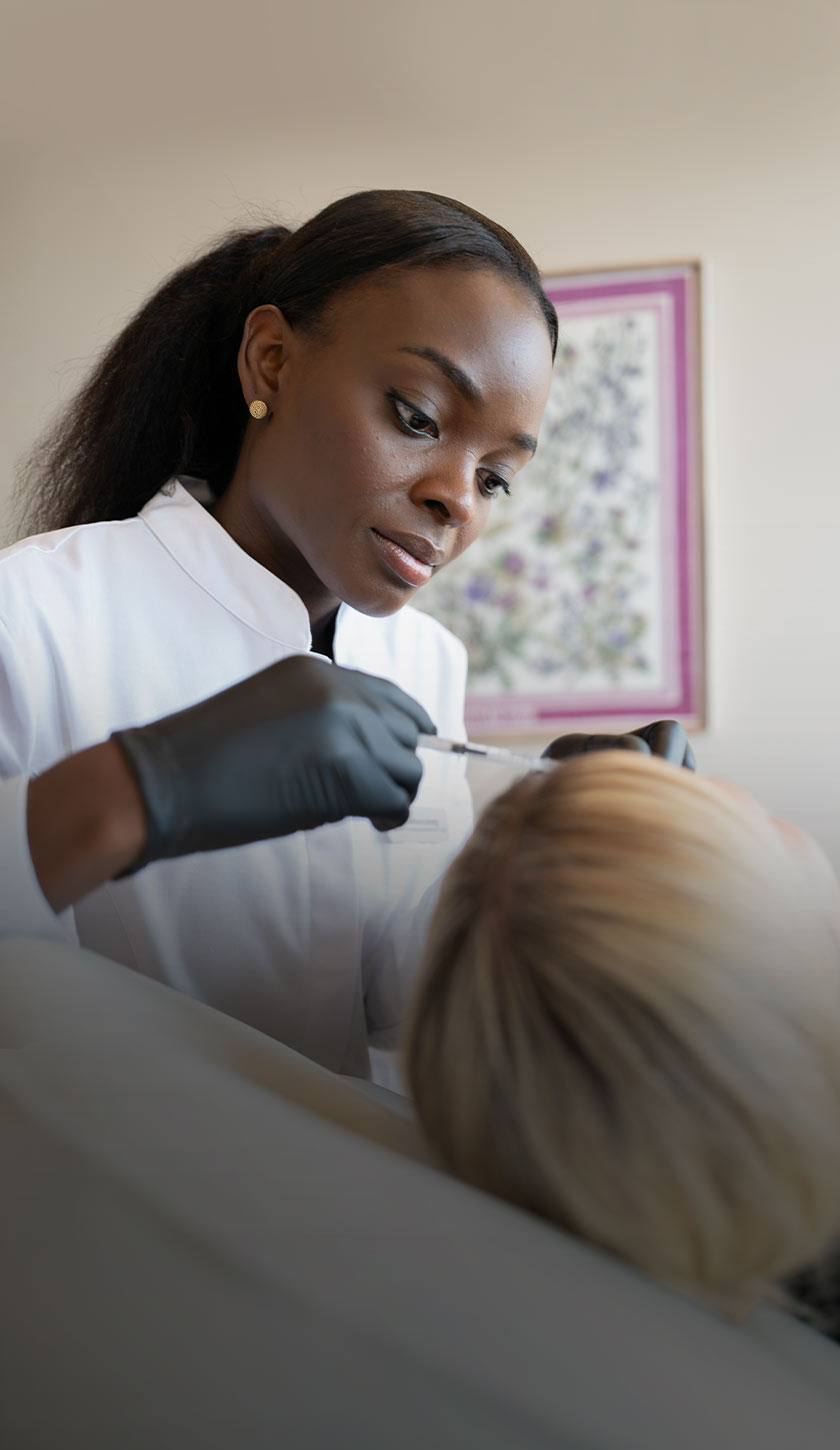 Dr. Loweg während einer ästhetischen Behandlung einer Patientin im aegz. in Darmstadt. 